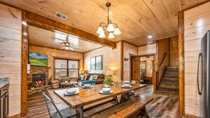 A wooden interior with a dining area, fireplace, and staircase. - ★Modern★ Family Friendly Cabin in Pigeon Forge - Hot Tub Game Room Fire Pit (Pigeon Forge)