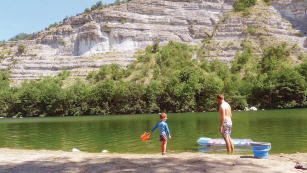 A lake with a rocky cliff in the background.