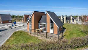A modern building with a sloped roof, large windows, and a paved driveway. - Awesome home in Hadsund with kitchen (Hadsund)