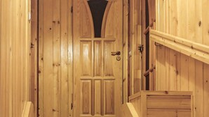 Une porte en bois avec une petite fenêtre au-dessus, une poignée en métal et un trou de serrure.