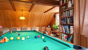 A pool table with balls, a bookshelf, and wooden walls. - Cozy apartment in Herrnhut OT Ruppersdor (Herrnhut)