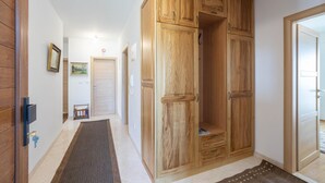 Un pasillo con armarios de madera, una puerta con el letrero de prohibido fumar y un cuadro en la pared.