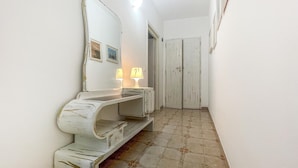 A hallway with a white vanity, a large mirror, and a door. - Lovely home in Marina di Lizzano with WiFi (Marina di Lizzano)