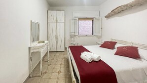A bedroom with a bed, a dresser, a mirror, a window, and a wooden beam on the wall. - Lovely home in Marina di Lizzano with WiFi (Marina di Lizzano)