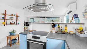 A modern kitchen with a central island, built-in oven, and a stainless steel range hood. - Nice home in Hurup Thy with kitchen (Hurup Thy)