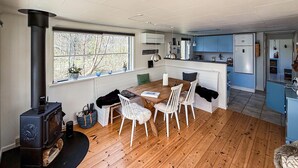 A modern kitchen with a central island, wooden flooring, and a large window with a view of trees. - Nice home in Hurup Thy with kitchen (Hurup Thy)