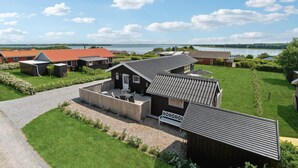 Un quartier résidentiel composé de plusieurs maisons, avec une allée en gravier et un lac en arrière-plan.