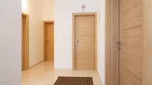 A hallway with wooden doors, a tiled floor, and a rug. - Nice apartment in Podstrana with WiFi (Podstrana)