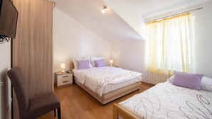 A bedroom with two beds, a wooden wardrobe, a desk, and a chair. - Nice apartment in Podstrana with WiFi (Podstrana)