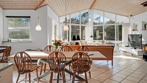 Una cocina amplia con una isla grande, sillas de madera y una mesa de comedor.