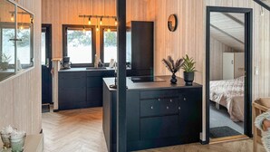 Une cuisine moderne avec un plan de travail noir, des meubles en bois et une grande fenêtre.