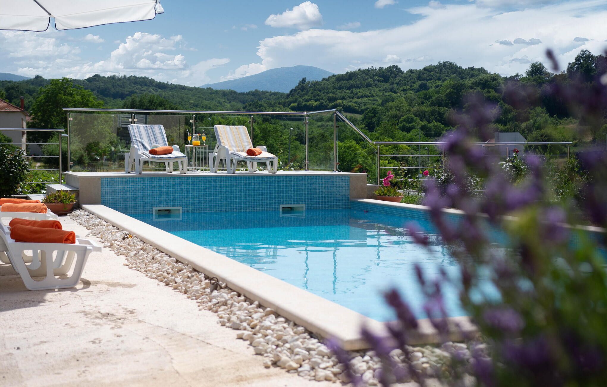 Een buitenzwembad en ligstoelen