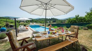 An outdoor dining area with a pool, surrounded by greenery and hills. - Amazing home in Suhac (Suhac)