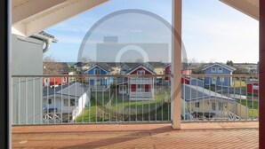 A balcony with a view of colorful houses and a clear sky. - Beautiful home in Süssau/Ostsee with sauna (Süssau/Ostsee)