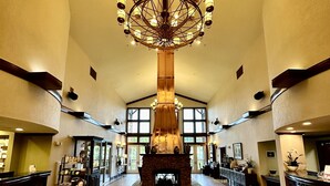 Un'ampia hall con un grande lampadario, un camino e una reception.