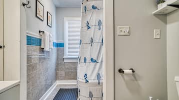 Tina con regadera, toallas, jabón, papel de baño