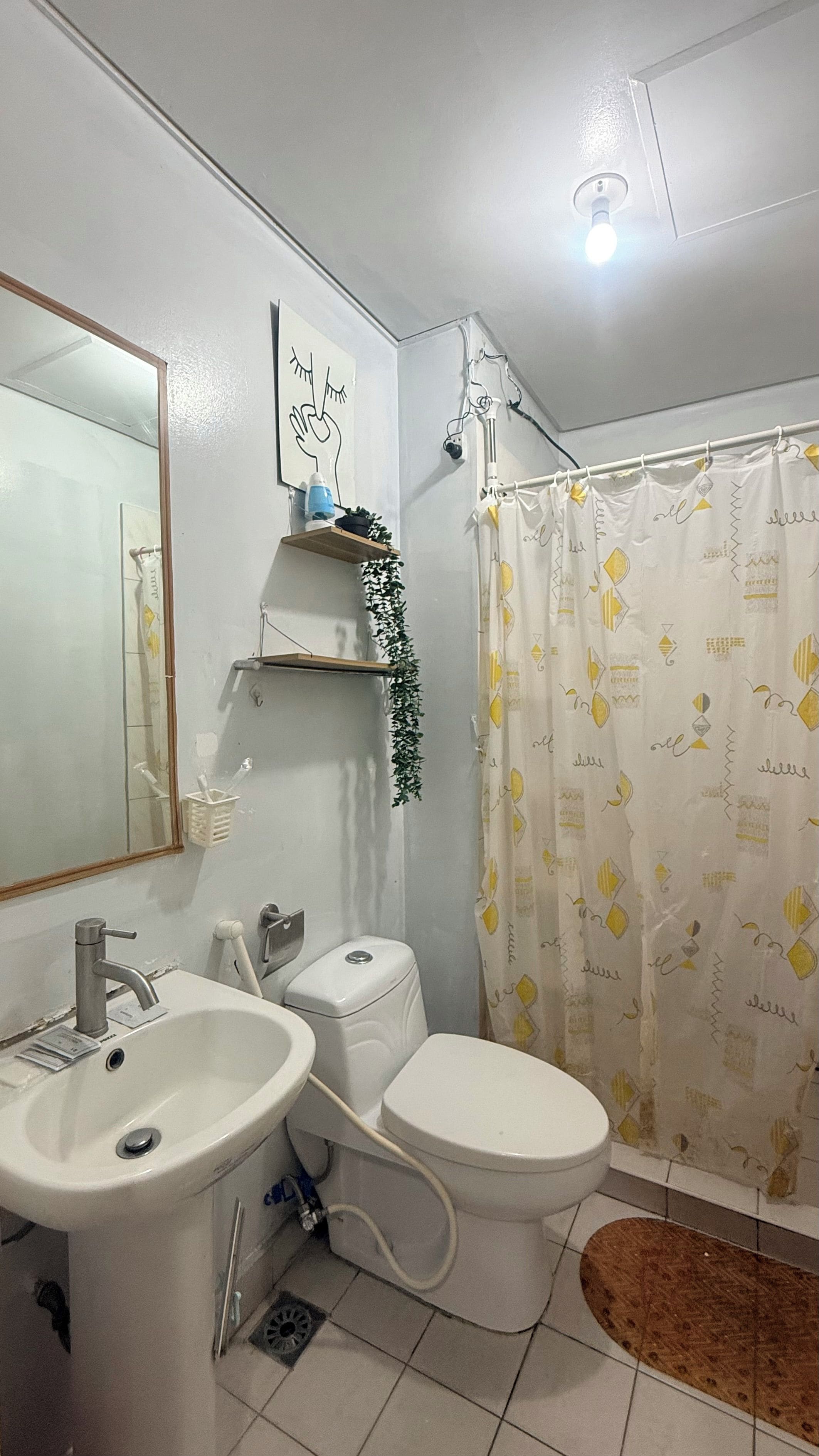 Une salle de bain équipée d’un lavabo, de toilettes et d’un rideau de douche.