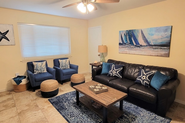 Welcome to Simply Beachy. Living area has a Murphy bed and sleeper sofa.