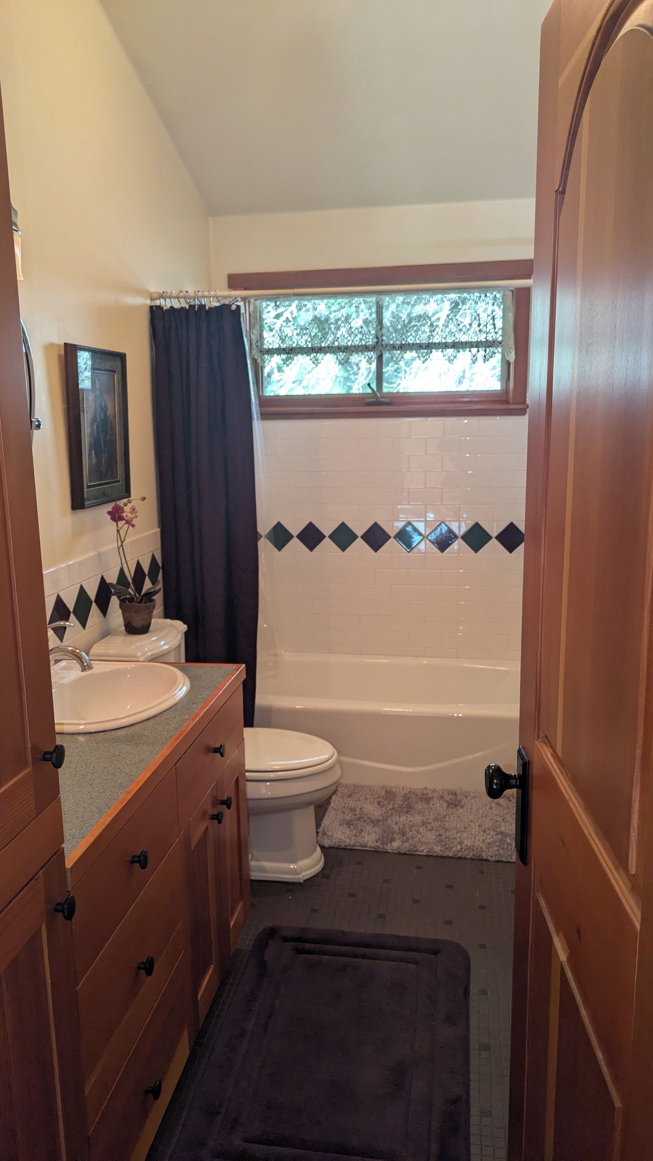 Ein Badezimmer mit Badewanne, Toilette, Waschtisch und Spiegel.