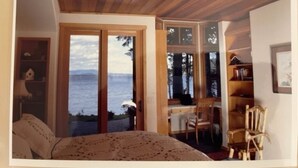 Une chambre avec une grande fenêtre, un bureau et une chaise.