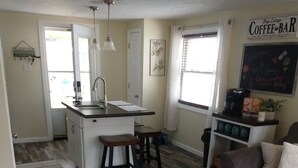 A compact living space with a kitchen area, a coffee bar, and a seating area with a couch and a coffee table. - Keys cottage -walk to the strip,Private lot, 2bdr 3rd guestroom detached.Spire (Geneva)