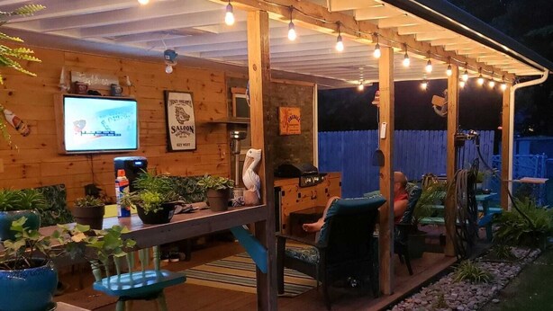 An outdoor patio area with a wooden deck, string lights, and potted plants. - Keys cottage -walk to the strip,Private lot, 2bdr 3rd guestroom detached.Spire (Geneva)