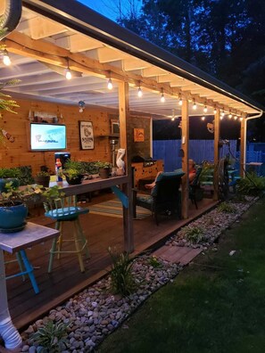 An outdoor patio area with a wooden deck, string lights, and potted plants. - Keys cottage -walk to the strip,Private lot, 2bdr 3rd guestroom detached.Spire (Geneva)