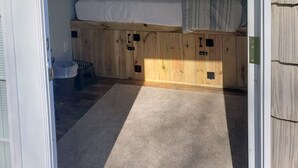 A bedroom with a wooden platform bed, white bedding, a ceiling light, and a small wall-mounted decoration. - Keys cottage -walk to the strip,Private lot, 2bdr 3rd guestroom detached.Spire (Geneva)