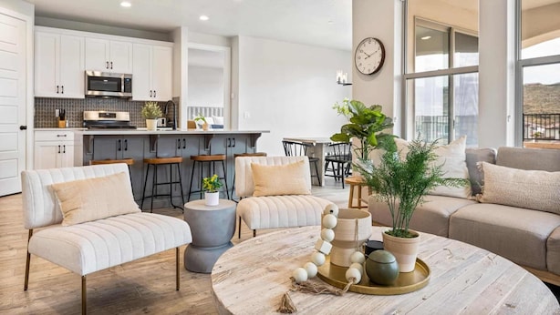 A modern living room with a round coffee table, a sofa, and a dining area with bar stools. - Zion's Gateway Retreat by RedAwning (Washington)