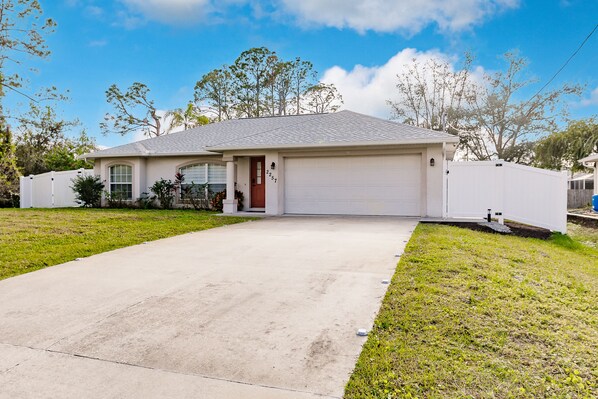 A single-story house with a garage, a front lawn, and a driveway.