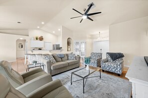 Relax in this spacious living area with a sofa, armchairs, and coffee table.