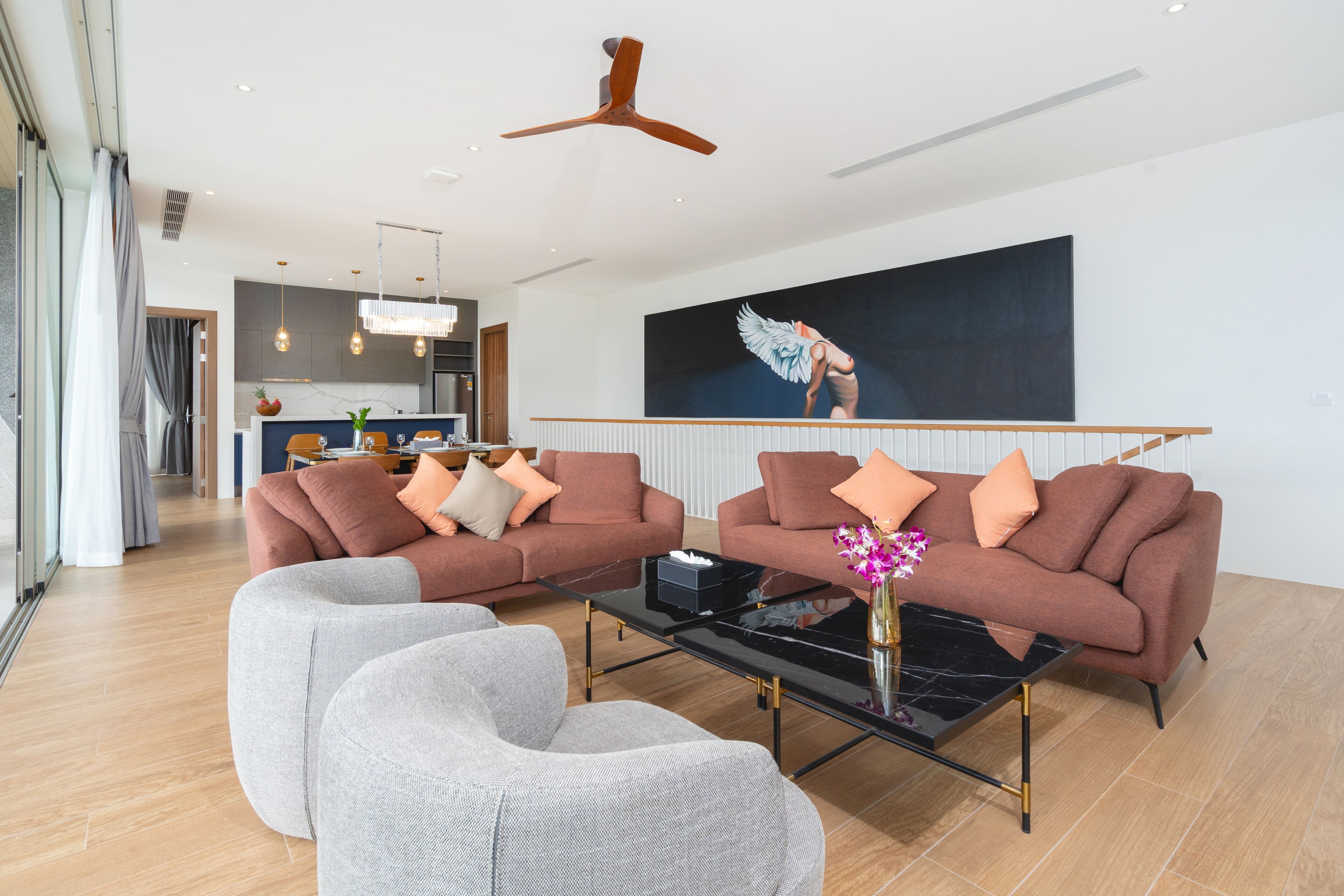 Een moderne woonkamer met twee banken, een salontafel en een eethoek op de achtergrond.