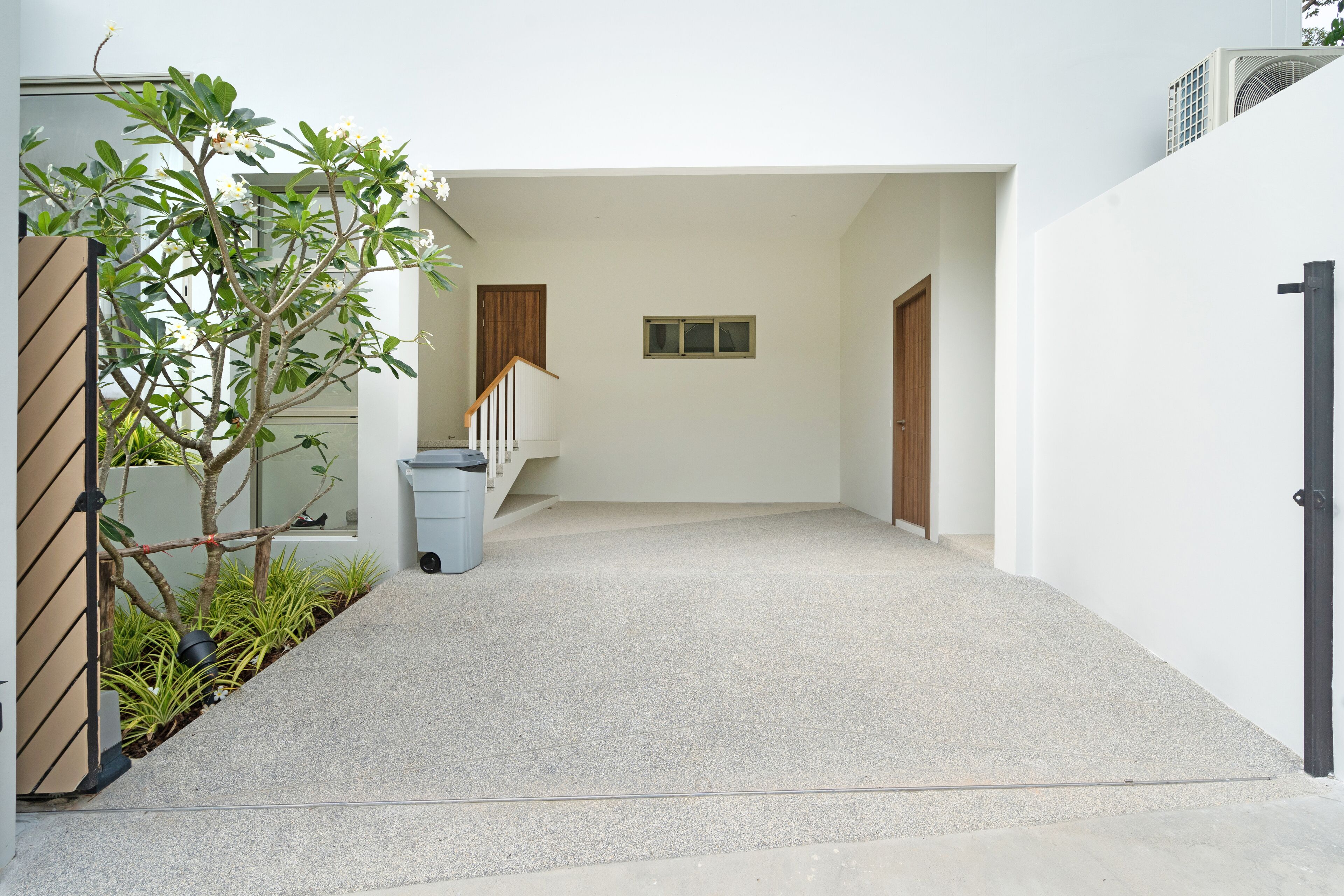 A modern building with a clean, minimalist design, featuring a concrete staircase, a small window, and a door.