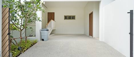 A modern building with a clean, minimalist design, featuring a concrete staircase, a small window, and a door.
