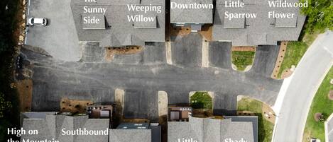 An aerial view of a residential area with houses labeled with names like "The Sunny Side," "Weeping Willow," and "Wildwood Flower."