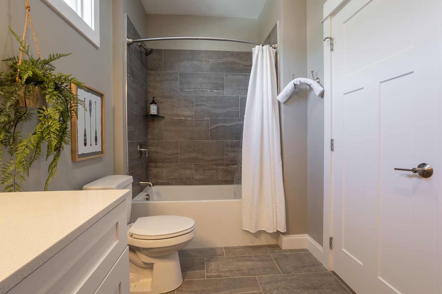 A bathroom with a bathtub, toilet, and a shower curtain.