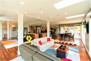 A spacious living area with a sofa, coffee table, and a dining area with chairs and a table. - New Listing - Breathtaking vacation/work remotely in wine country! (Forest Grove)