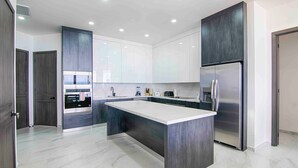 Una cocina moderna con una isla central, electrodomésticos integrados y un diseño elegante.