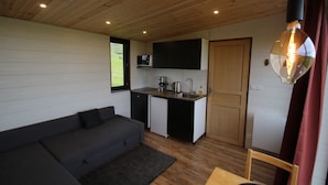 A compact living space with a kitchenette, a sofa, and a dining area.