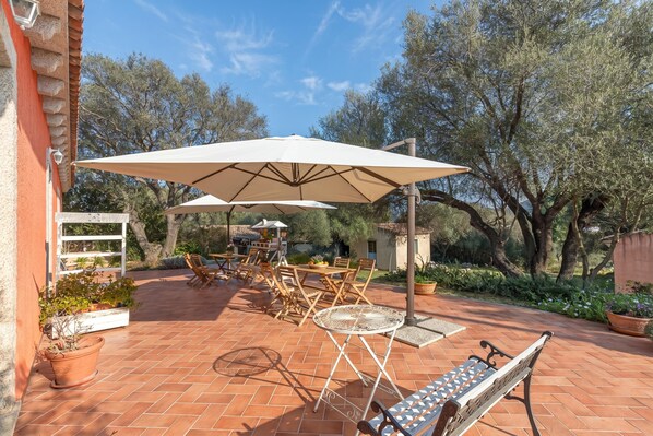 A patio with outdoor furniture, including a table and chairs, and a bench.