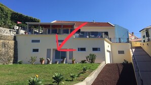 A two-story building with a flat roof, multiple windows, and a balcony.