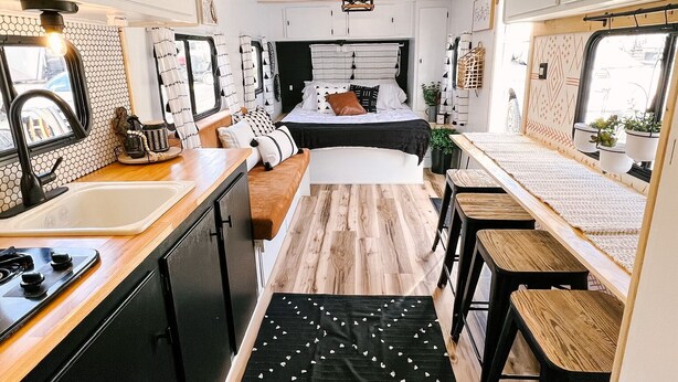 A compact RV kitchen with a central island, a stove, and a sink. - Cute Renovated RV Near Zion & St. George (Leeds)