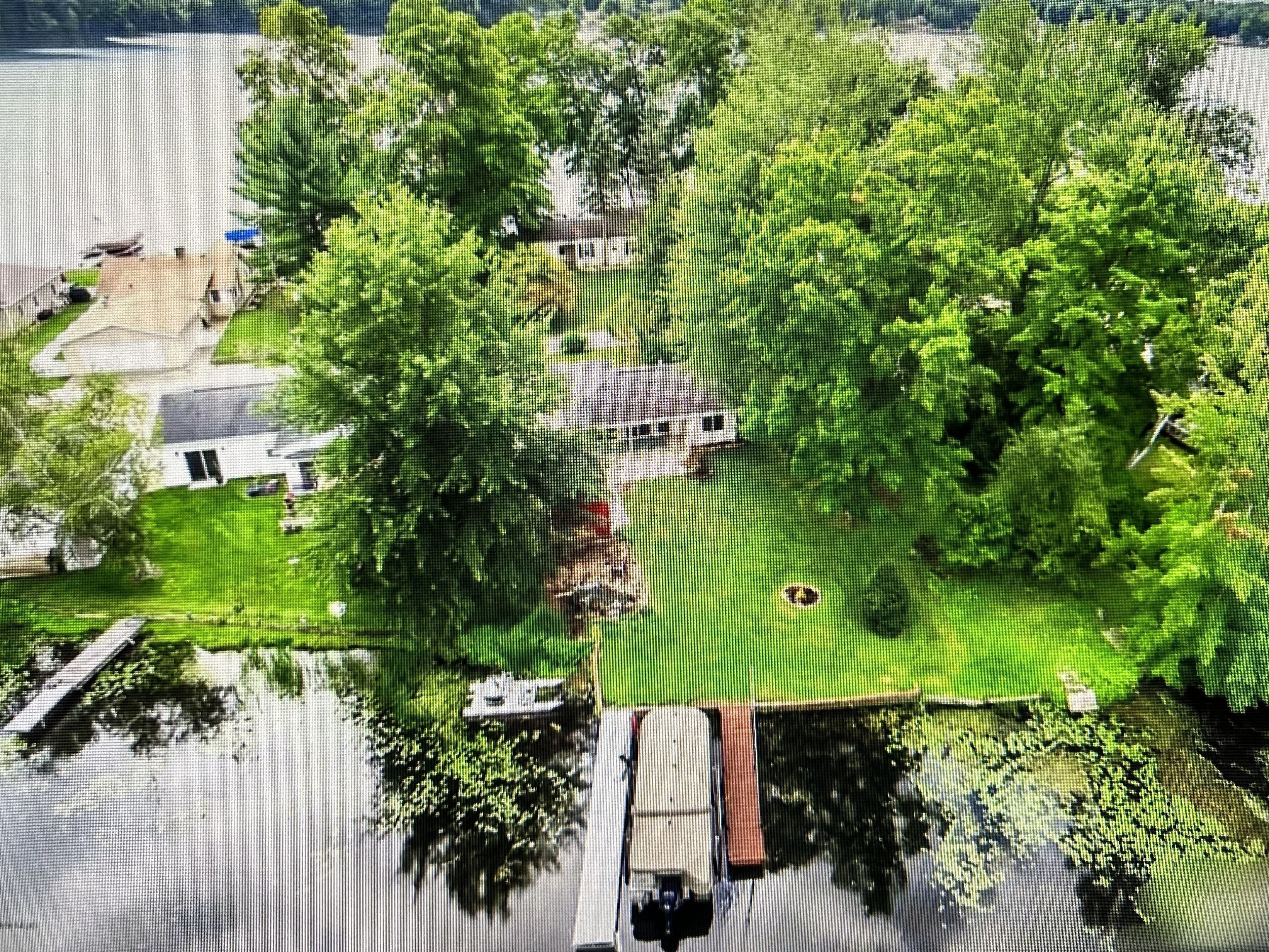Um bairro residencial com casas, um cais e um barco em um lago.