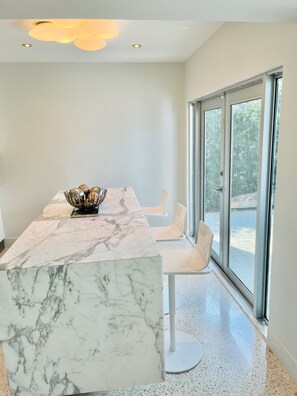 Enjoy meals in a stylish dining area with a large window offering a view of the outdoors.