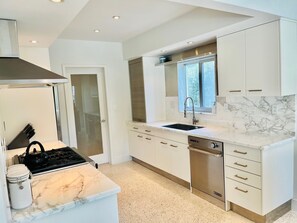 Enjoy cooking in this well-equipped kitchen with a stainless steel range hood, dishwasher, and double sink.