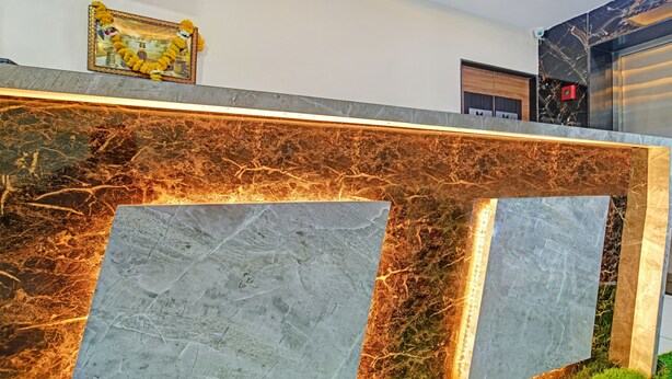 A reception desk with a marble top and a framed picture above it.