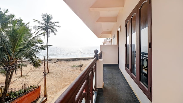 A balcony with a view of the beach and ocean. - Itsy Hotels The Waters Edge Beach Resort (Neyyattinkara)