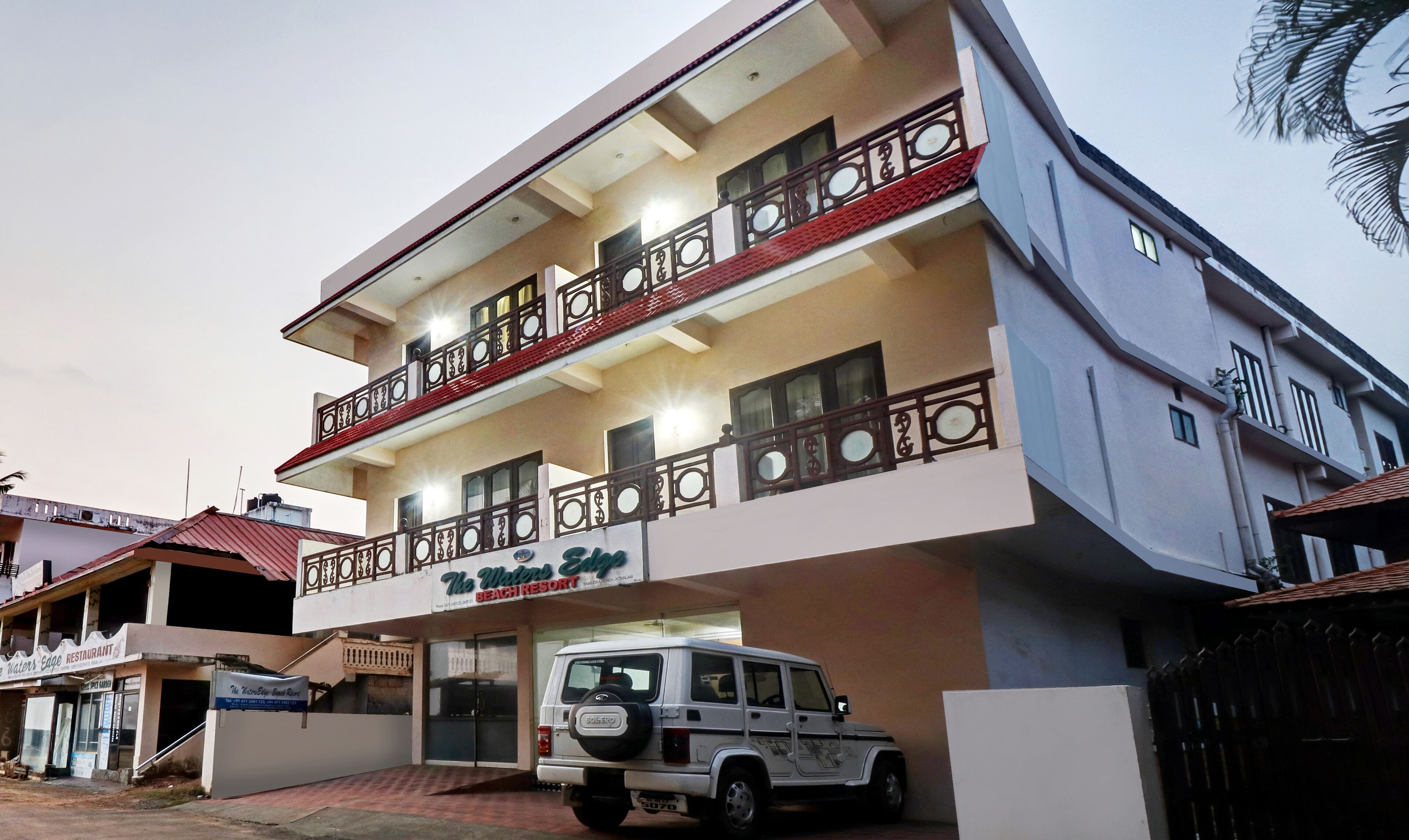 A two-story building with a sign for 'The Waters Edge Beach Resort'.