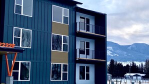 A multi-story building with a dark exterior, multiple windows, and balconies. - Paradise Valley View Getaway (Livingston)