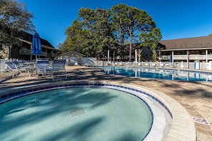 A swimming pool with lounge chairs and a covered area, surrounded by trees and buildings. - FREE Street Legal GOLF CART for Beach & Shopping, 5 Pools/Pickleball/Tennis~Charming Seascape Villa (Miramar Beach)